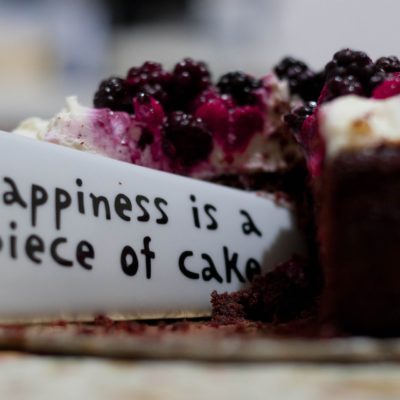 a piece of birthday cake saying happiness is a piece of cake